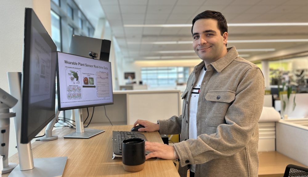 Sina Jamalzadegan at his desk reviewing wearable plant sensor data